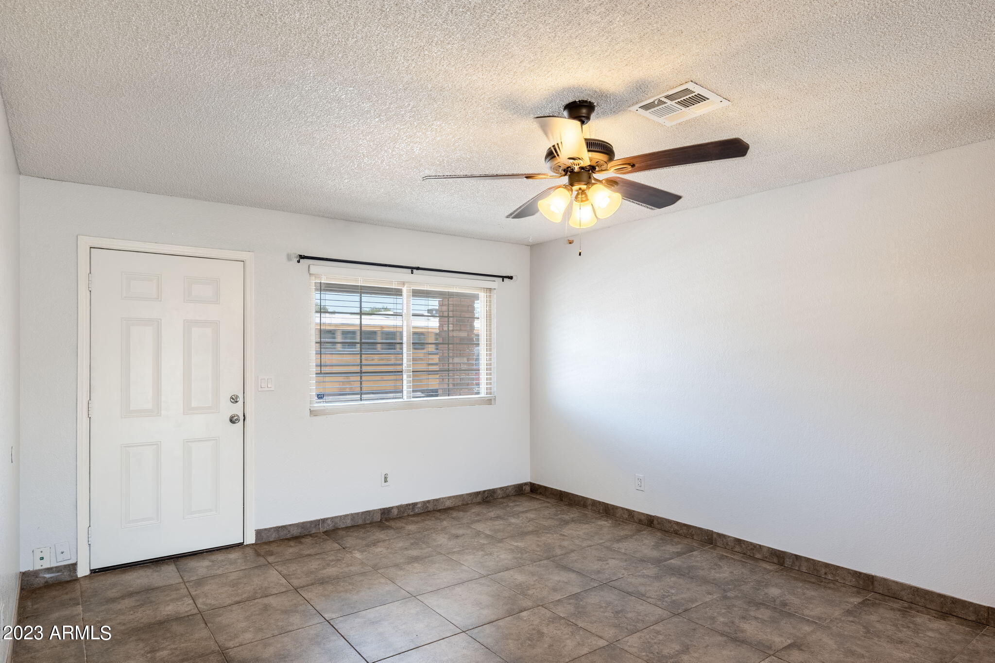 964 West Hackamore Street Mesa, AZ 85201 - Photo 5 of 24 an empty room with a window and a fan
