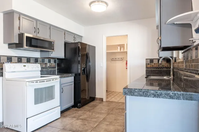 a kitchen with stainless steel appliances granite countertop a stove a refrigerator and a sink