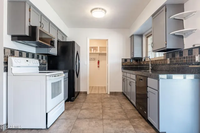 a kitchen with a stove top oven and refrigerator