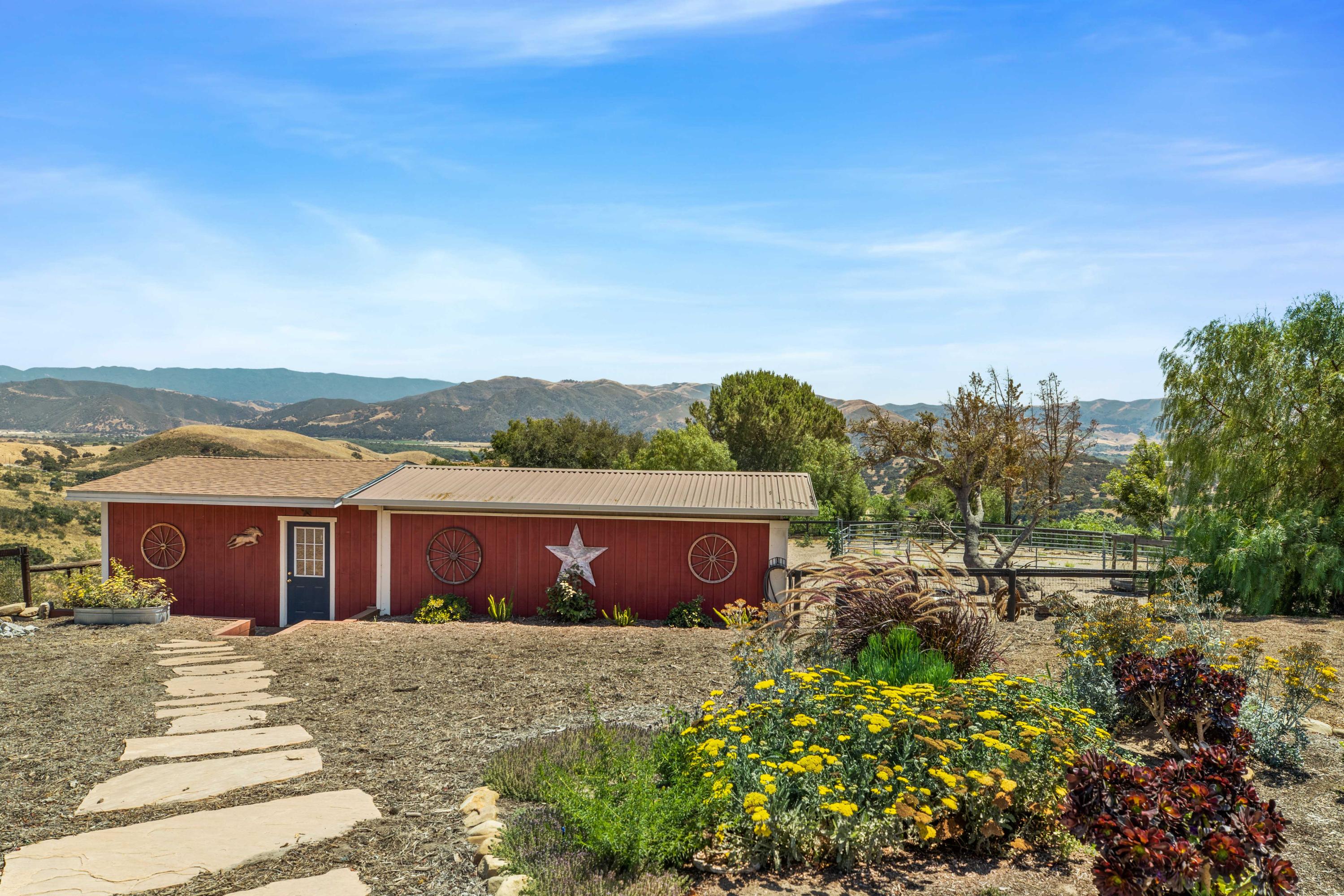 1833 Cougar Ridge Road Buellton, CA 93427 - Photo 33 of 49 a view of a house with a yard and table and chairs under an umbrella