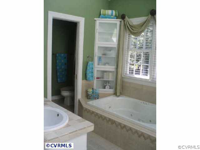 14310 West Salisbury Road Midlothian, VA 23113 - Photo 7 of 9 a bathroom with a tub and a sink