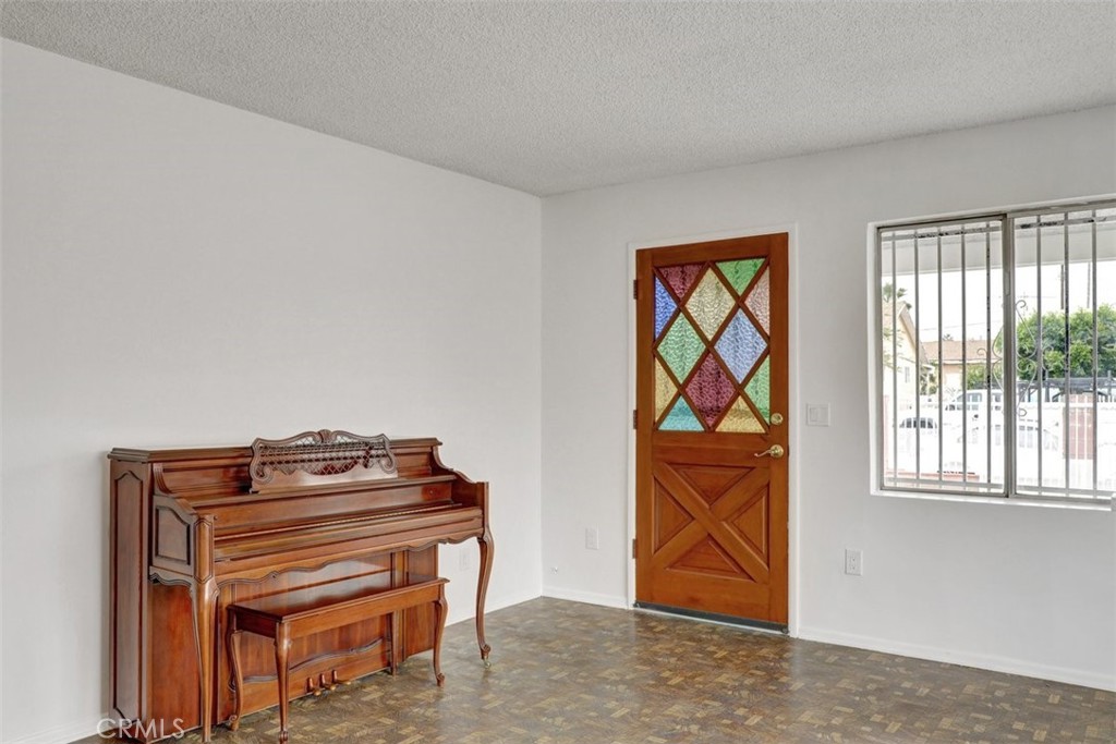 10661 Ilex Avenue Pacoima, CA 91331 - Photo 5 of 22 a room with a piano and wooden floor