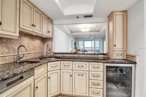 a living room with furniture kitchen view and a wooden floor