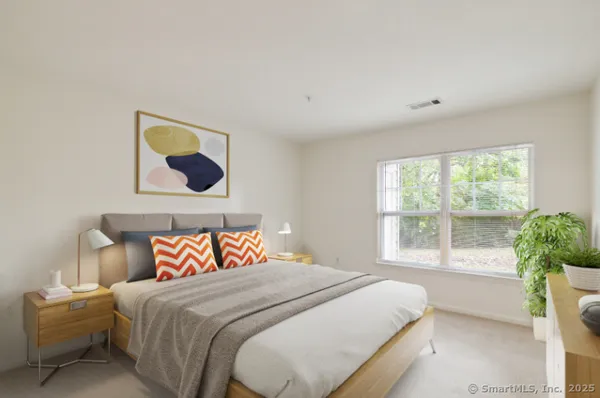 a bedroom with a bed and a painting on the wall