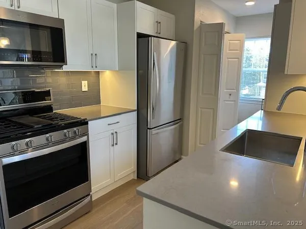 a kitchen with stainless steel appliances granite countertop a refrigerator stove and microwave