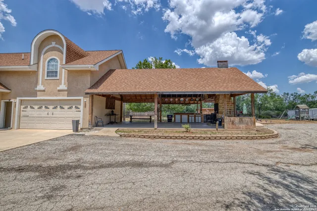 a view of a patio with table and chairs under an umbrella with a small yard