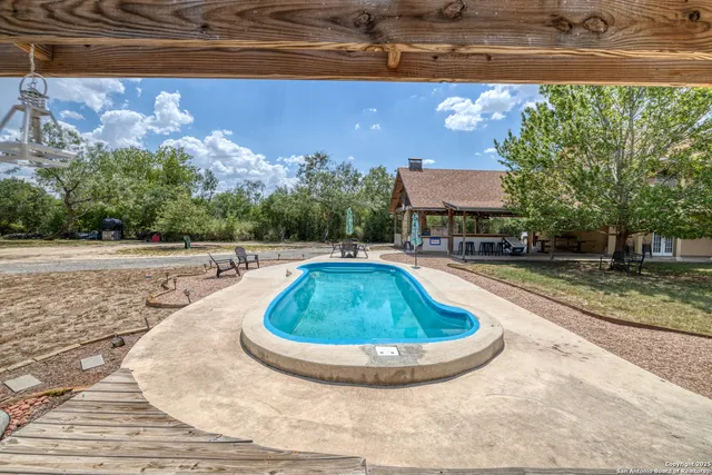 a swimming pool with outdoor seating and yard