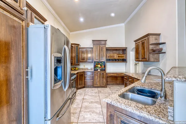 a kitchen with granite countertop a refrigerator and a sink