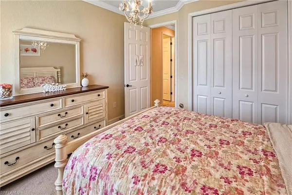 a bedroom with a large bed and a mirror on dresser