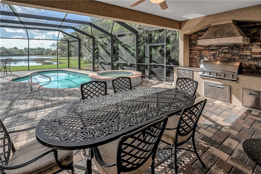 9215 Veneto Lane Naples, FL 34113 - Photo 17 of 34 a roof deck with a dining table and chairs with wooden floor