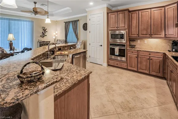 a kitchen with sink a stove and chairs