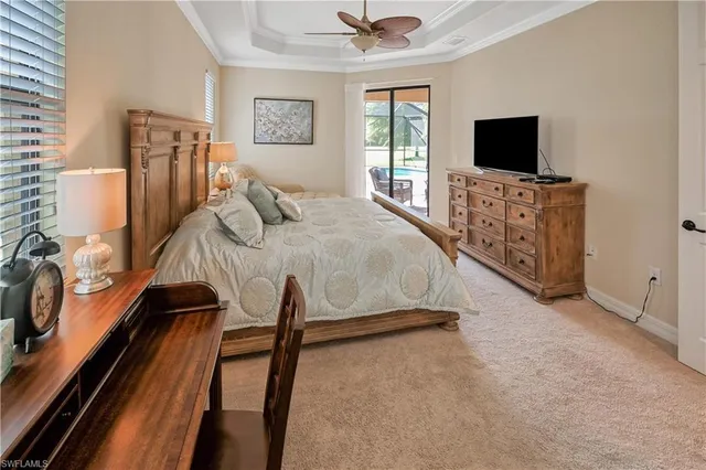 a bedroom with a bed and a flat tv screen on dresser