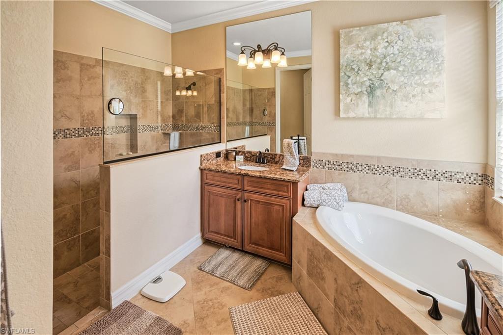 9215 Veneto Lane Naples, FL 34113 - Photo 9 of 34 a bathroom with a tub sink and mirror