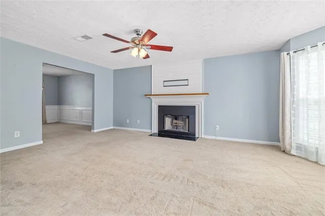 a view of an empty room with window and fireplace
