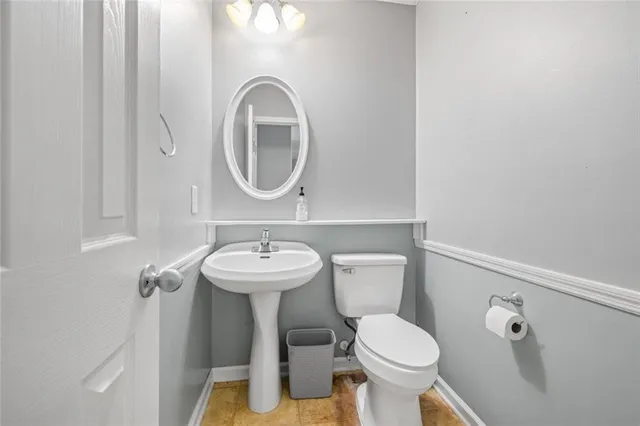 a bathroom with a toilet sink and mirror