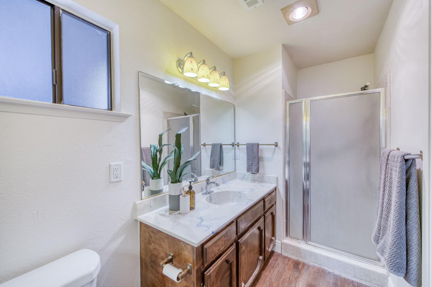 133 North Cindy Avenue Clovis, CA 93612 - Photo 14 of 19 a bathroom with a sink a toilet and a mirror