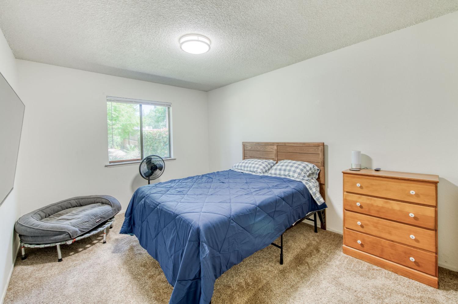 133 North Cindy Avenue Clovis, CA 93612 - Photo 15 of 19 a bedroom with a bed and a chair