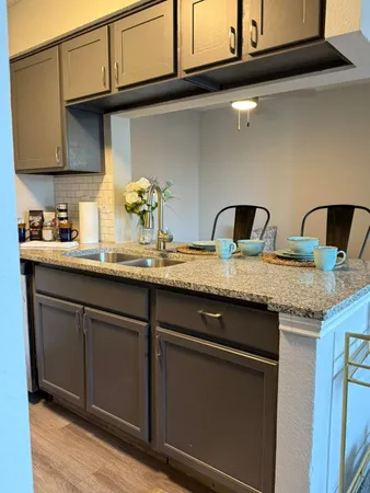 a bathroom with a granite countertop sink a toilet a mirror and vanity