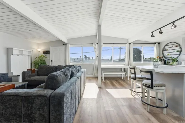 a living room with stainless steel appliances kitchen island granite countertop furniture and a wooden floor