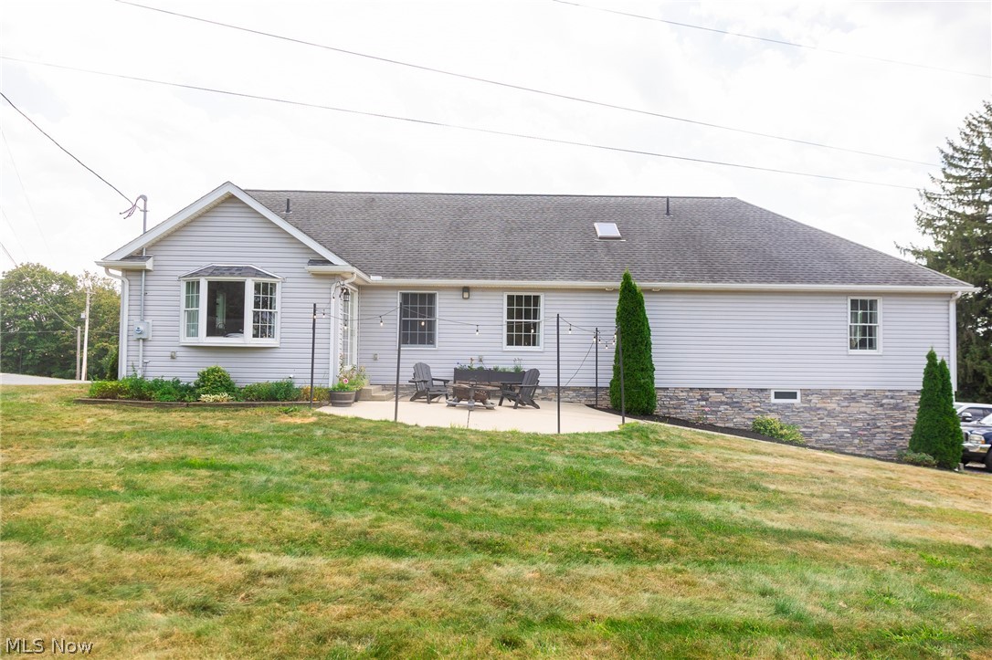 9554 Dover Road Apple Creek, OH 44606 - Photo 5 of 45 Rear view of house with a patio area, a lawn, and a shingled roof