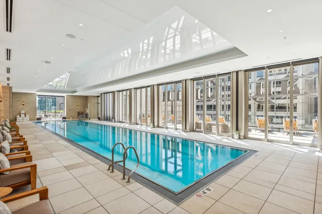 a room with lots of tables a large window and chairs