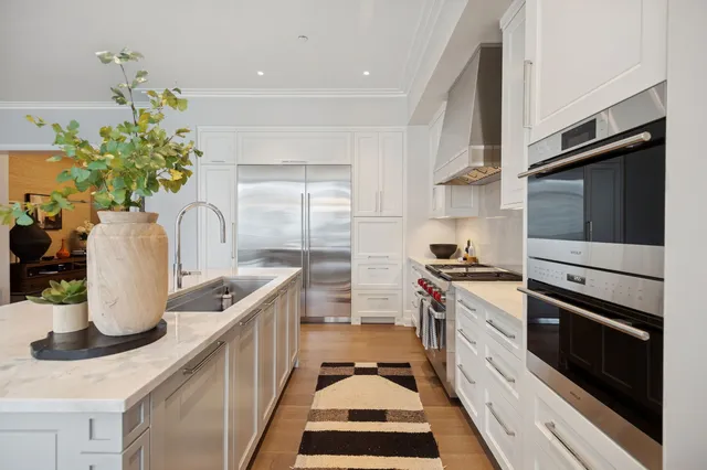 a kitchen with stainless steel appliances a sink a stove and cabinets