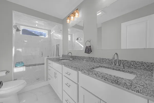 a bathroom with double sink and a mirror