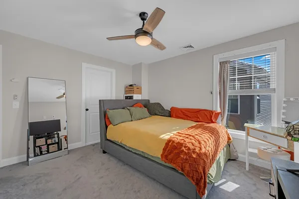 a bedroom with a bed a window and a chandelier