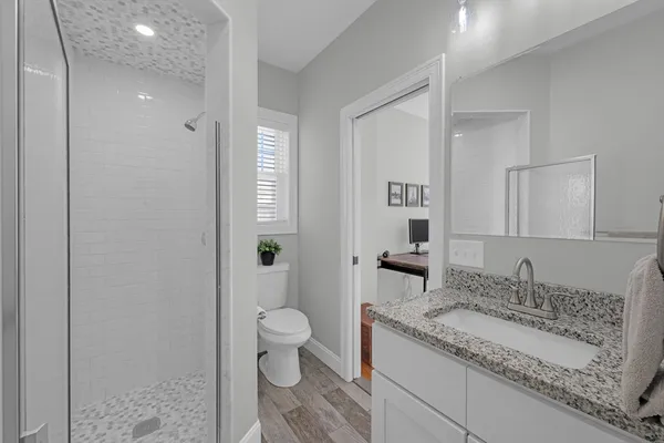 a spacious bathroom with a granite countertop sink and a mirror