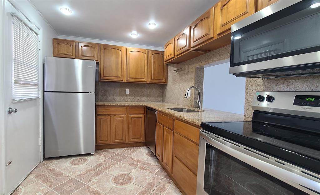 a kitchen with a refrigerator sink and cabinets