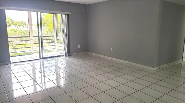 an empty room with chandelier fan