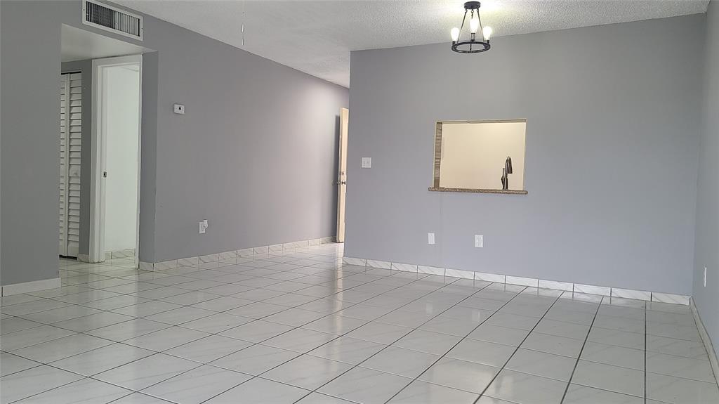 2800 Northwest 56th Avenue, Unit A305 Lauderhill, FL 33313 - Photo 5 of 15 an empty room with chandelier fan