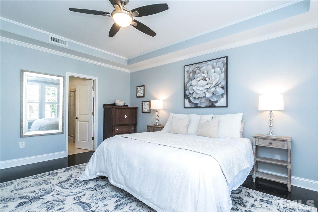 1407 Rodessa Run Raleigh, NC 27607 - Photo 14 of 30 a bedroom with a large bed and a chandelier