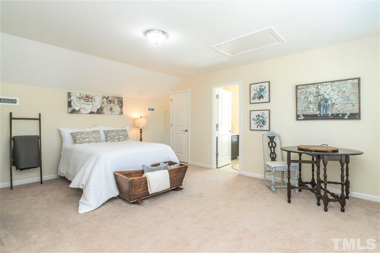 1407 Rodessa Run Raleigh, NC 27607 - Photo 22 of 30 a spacious bedroom with a bed and a table in it