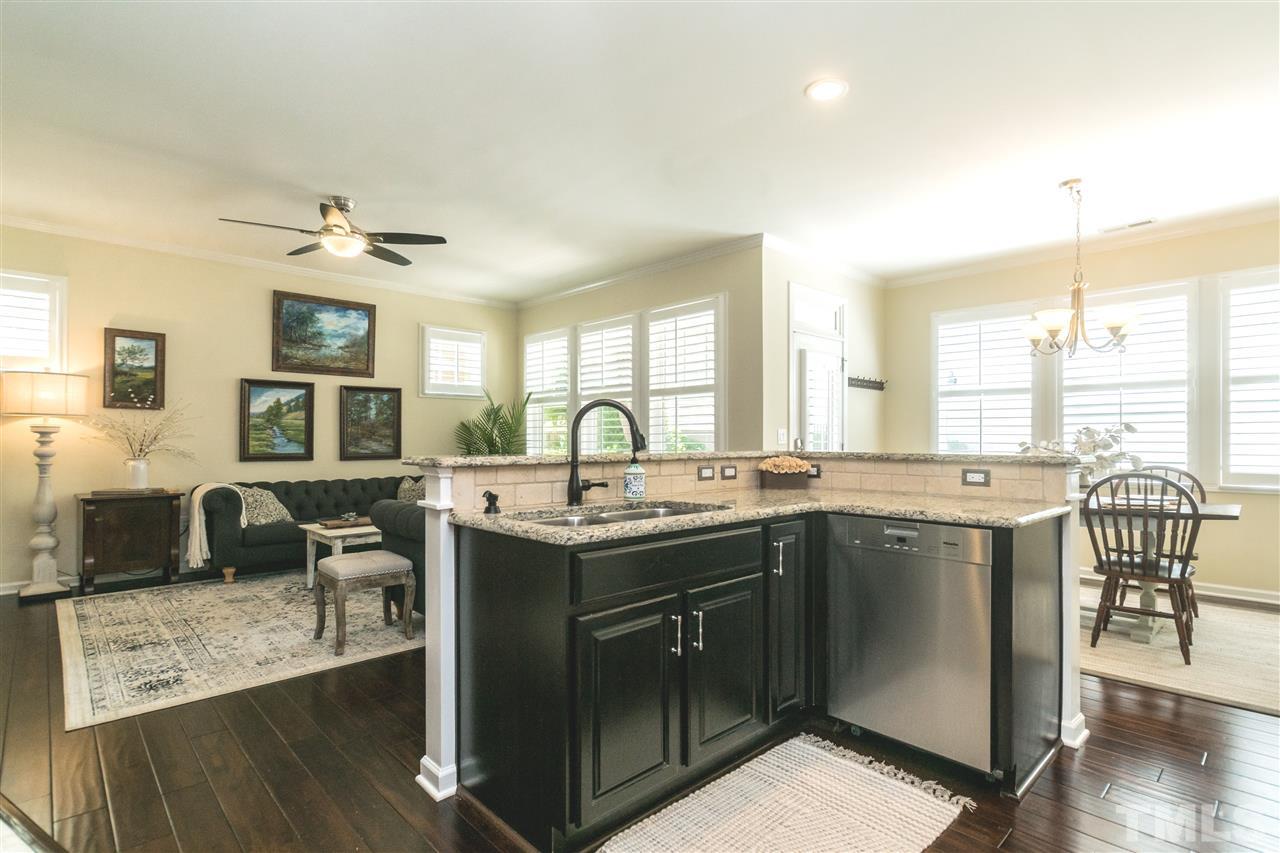 1407 Rodessa Run Raleigh, NC 27607 - Photo 7 of 30 a open kitchen with stainless steel appliances granite countertop a stove top oven a sink dishwasher and chairs with wooden floor