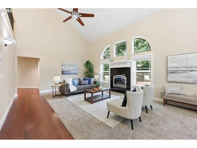 a living room with furniture a fireplace and a floor to ceiling window