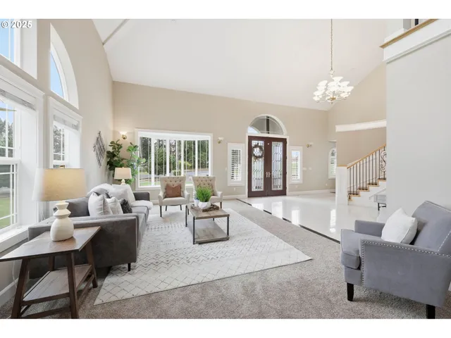 a living room with furniture a chandelier and a dining table