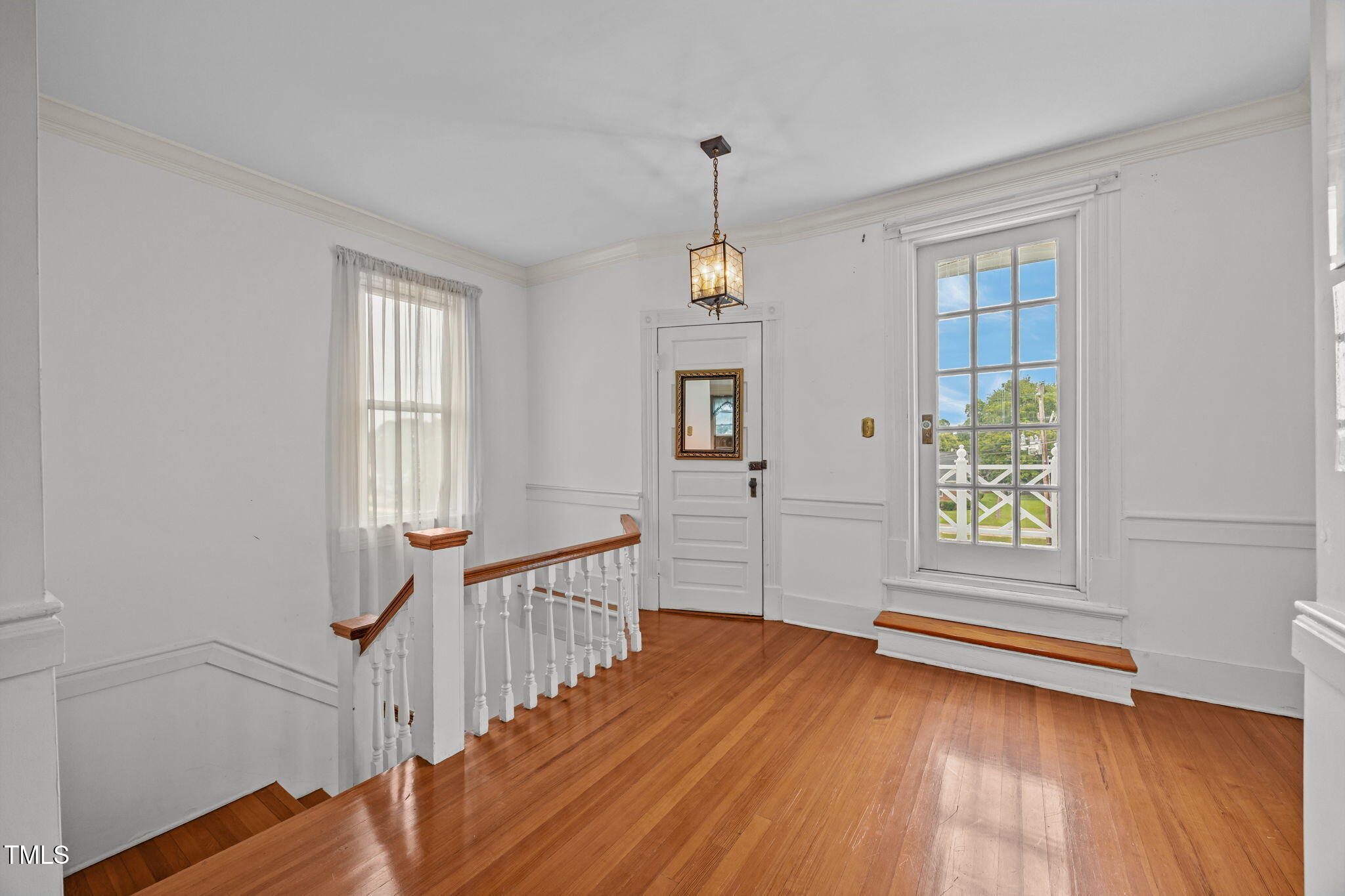 301 East H Street Erwin, NC 28339 - Photo 27 of 58 an empty room with wooden floor and windows