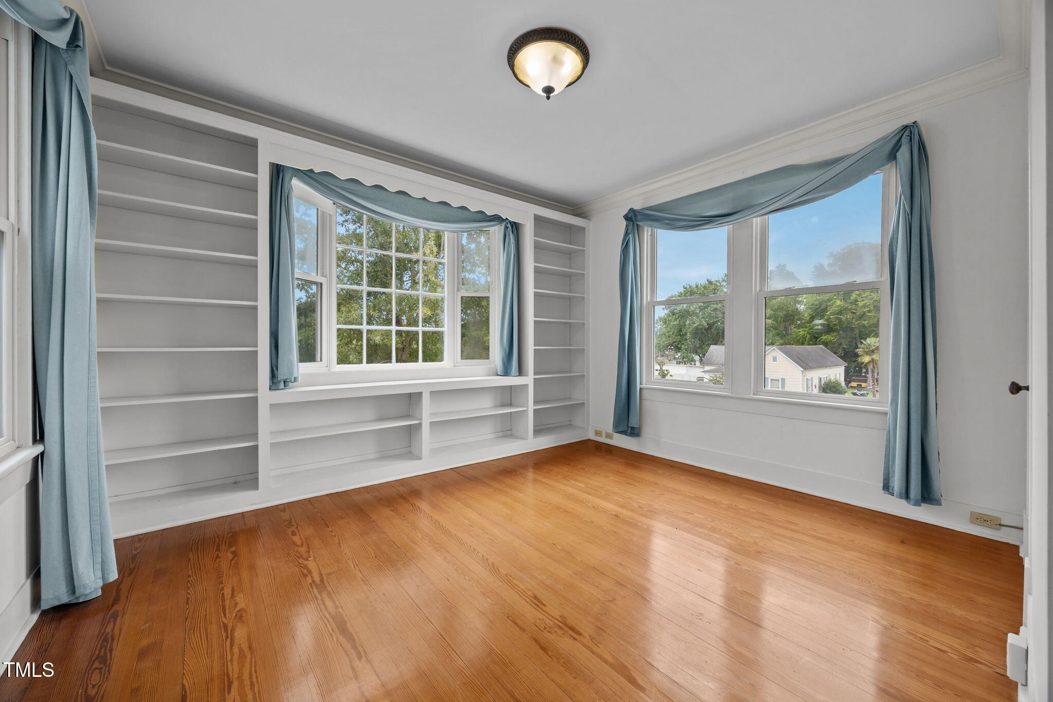 301 East H Street Erwin, NC 28339 - Photo 30 of 56 a view of an empty room with a window and wooden floor