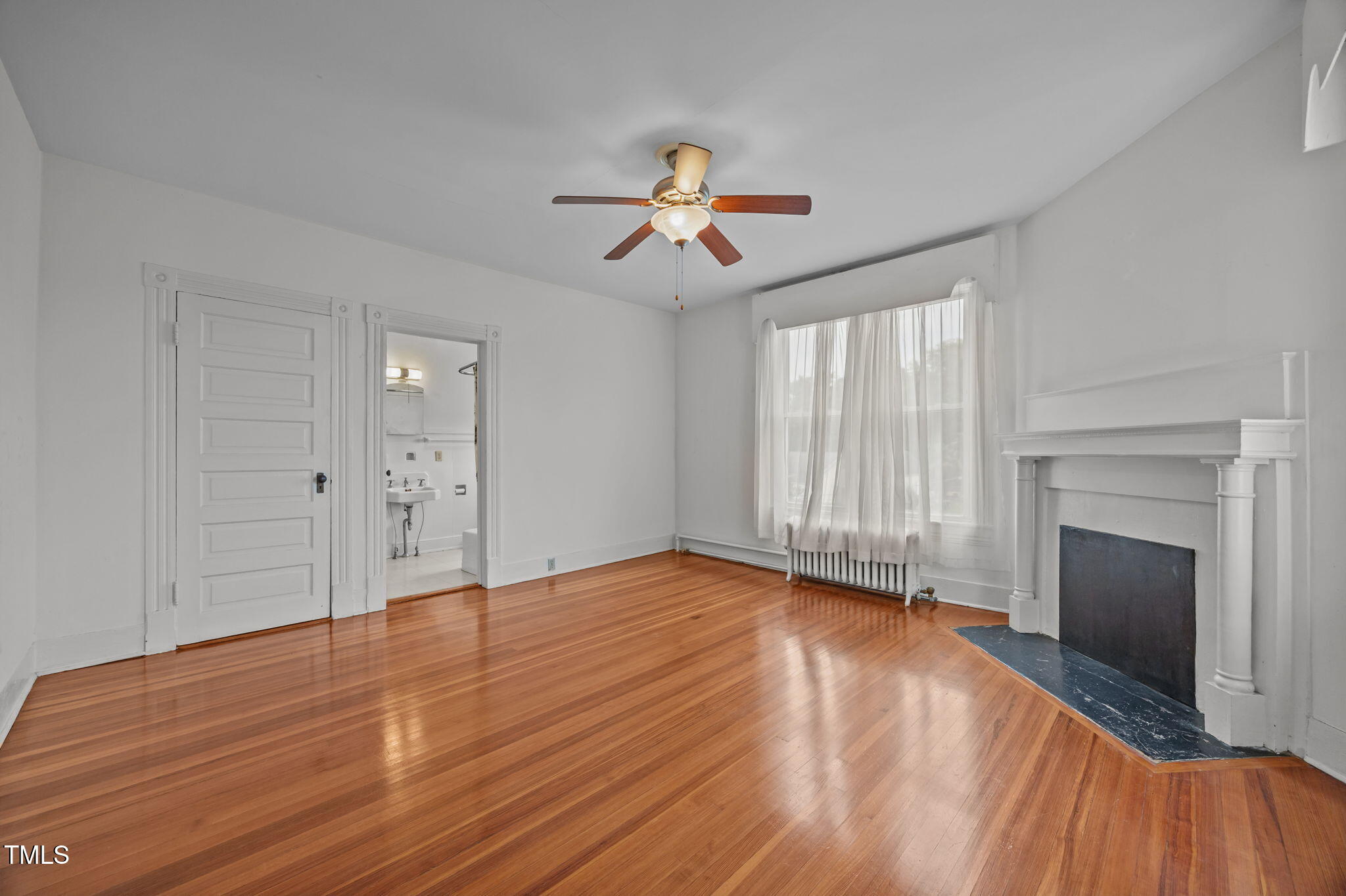 301 East H Street Erwin, NC 28339 - Photo 34 of 58 wooden floor fireplace and windows in an empty room