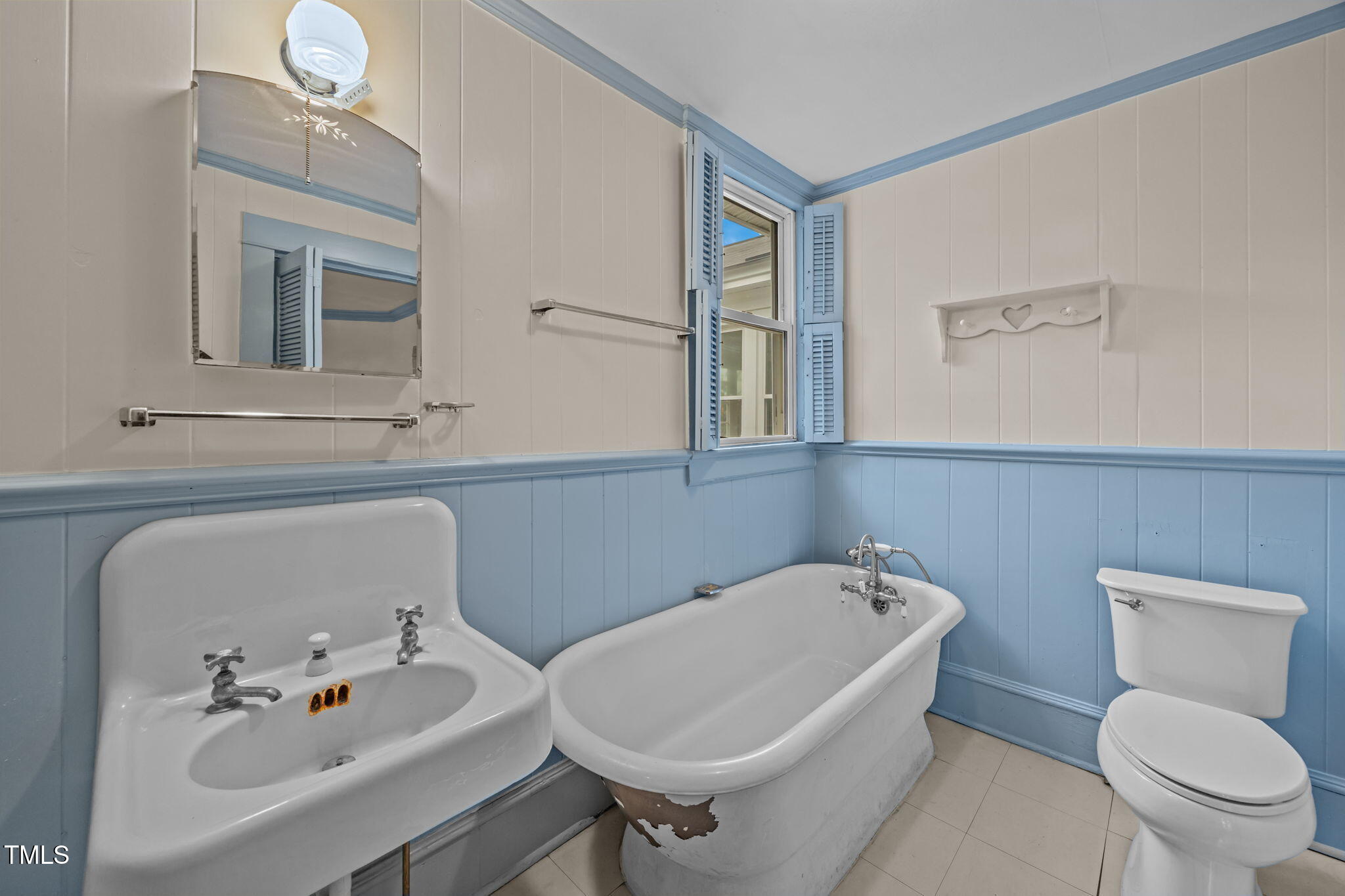 301 East H Street Erwin, NC 28339 - Photo 37 of 56 a bathroom with a sink a toilet and mirror