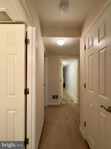a view of a hallway with wooden floor and closet area