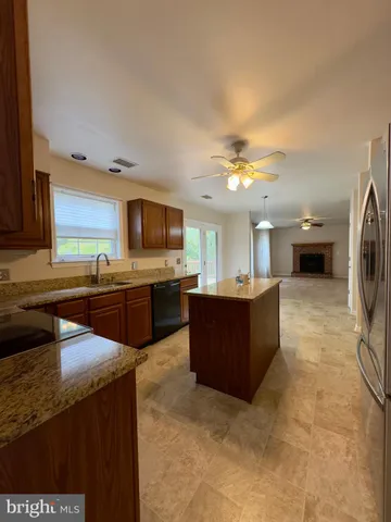 a kitchen with stainless steel appliances granite countertop a sink and a refrigerator