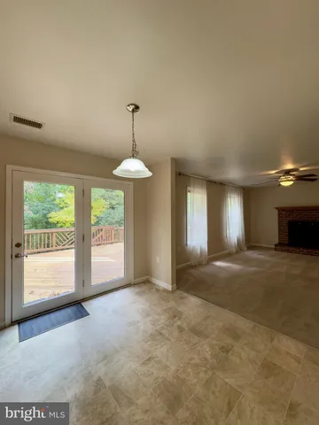an empty room with windows and fireplace