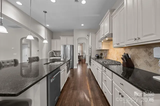 a large kitchen with stainless steel appliances lots of counter space and a sink