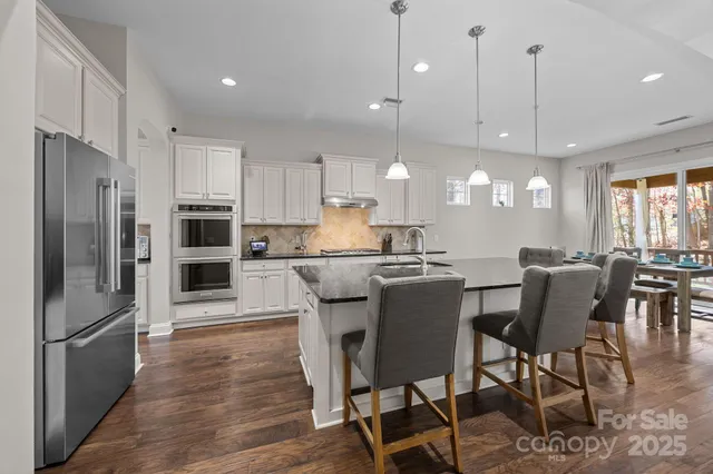 a kitchen with stainless steel appliances a refrigerator and wooden floor