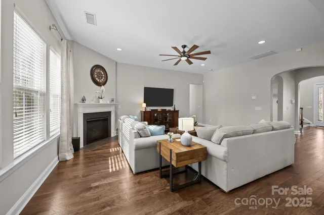 a living room with furniture kitchen view and a large window