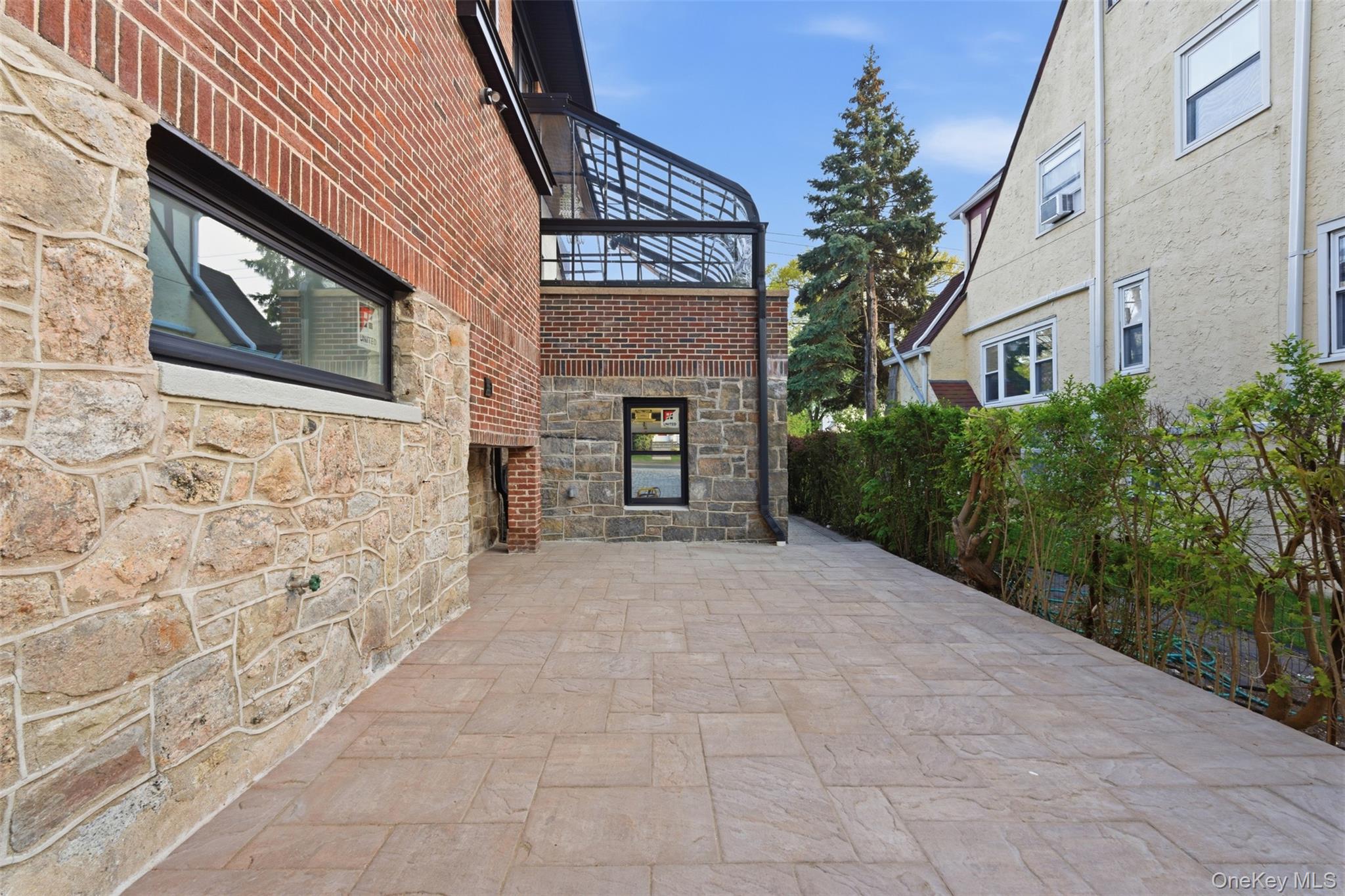 40 Calhoun Avenue New Rochelle, NY 10801 - Photo 37 of 49 Exterior stone and brick facade with black-framed windows