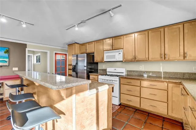 a kitchen with stainless steel appliances granite countertop a sink stove and cabinets