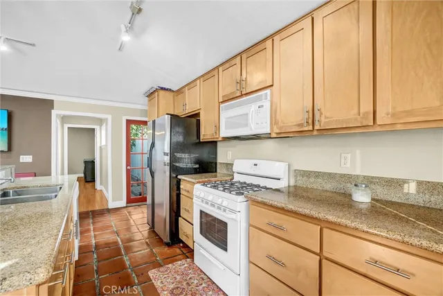 a kitchen with stainless steel appliances granite countertop a stove a sink and a refrigerator